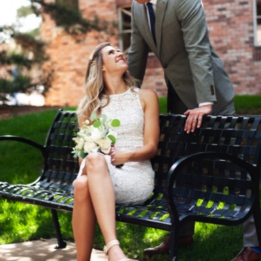 Couple in formal attire posing at a park bench in Denver during a professional couples wedding engagement portrait photography session by Kay Fritze of Fritze Media