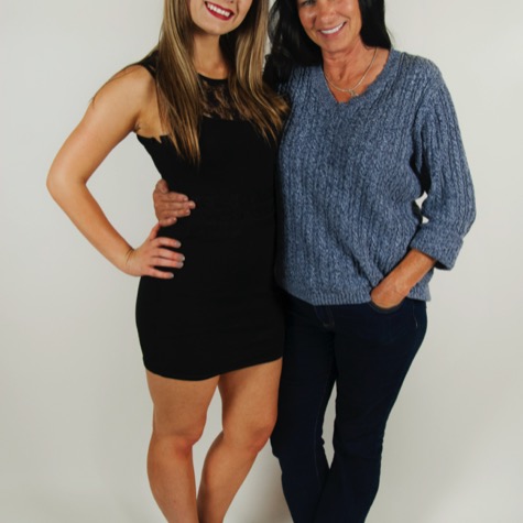 Two women smiling and posing side by side against a seamless white background during a professional studio portrait photography session by Kay Fritze of Fritze Media