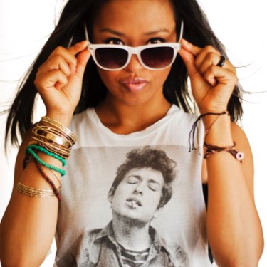 Young woman wearing white sunglasses and a graphic shirt posing for a stylish professional portrait by Kay Fritze of Fritze Media